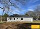 Rear view of a house with gray siding and a two-car garage, with a backyard ready for landscaping at 309 General As Johnston St, Stanley, NC 28164