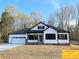 Beautiful home with white siding, a black roof, two-car garage, and a well-manicured lawn at 309 General As Johnston St, Stanley, NC 28164