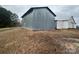 Large metal barn with a classic design, set on a grassy field with an adjacent building for added storage at 32341 Speiss Rd, Albemarle, NC 28001