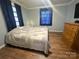 Comfortable bedroom with a cozy quilt, wood floors, and natural light, creating a relaxing retreat at 32341 Speiss Rd, Albemarle, NC 28001