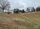 Exterior view of a home with a metal garage and sloping front yard in a rural setting at 32341 Speiss Rd, Albemarle, NC 28001