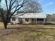 A charming ranch-style home featuring a classic front porch with a swing, surrounded by a leafy yard in a rural setting at 32341 Speiss Rd, Albemarle, NC 28001