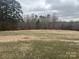 Expansive grassy field, perfect for outdoor activities, set against a backdrop of mature trees and open sky at 32341 Speiss Rd, Albemarle, NC 28001
