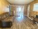 Cozy living room with a large window and wood-look floors, flowing into the adjacent kitchen and dining area at 32341 Speiss Rd, Albemarle, NC 28001