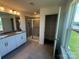 Modern bathroom features a double sink vanity, tiled floor, and a glass enclosed shower at 330 Knotty Wood Dr # 67, Monroe, NC 28110