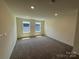 A carpeted bedroom with neutral walls and two windows at 330 Knotty Wood Dr # 67, Monroe, NC 28110