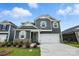 Charming two-story home with gray siding, stone accents, white trim, and an attached two-car garage at 330 Knotty Wood Dr # 67, Monroe, NC 28110