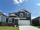 Charming two-story home featuring a two-car garage, stone accents, and a well-manicured front lawn at 330 Knotty Wood Dr # 67, Monroe, NC 28110