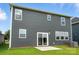 Back of house with gray siding, multiple windows, and a sliding glass door to the patio at 330 Knotty Wood Dr # 67, Monroe, NC 28110
