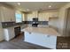 Bright kitchen boasts white cabinets, stainless appliances, gray backsplash and a large center island at 330 Knotty Wood Dr # 67, Monroe, NC 28110