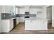 Bright kitchen featuring white cabinetry, stainless steel appliances, blue backsplash, and an island with countertop seating at 330 Knotty Wood Dr # 67, Monroe, NC 28110