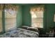 Bedroom with green walls, patterned curtains, and a floral comforter on the bed at 3694 Nc Highway 109 S Hwy, Mount Gilead, NC 27306