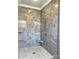 Close up of glass shower featuring granite-like tile walls, a built-in seat, and glass shelving at 3754 10Th Ne St, Hickory, NC 28601