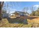 Exterior shot of the home showing the carport, shed, and trees in the front yard at 445 Cannon Farm Rd, China Grove, NC 28023