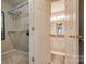 Open view of a walk-in closet leading to a bathroom with a vanity and mirror at 5009 Sharon Rd # E, Charlotte, NC 28210