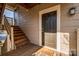 The front door of unit 17, with stairs leading to the entrance, set on a porch with a welcome mat at 5009 Sharon Rd # E, Charlotte, NC 28210