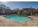 Community pool featuring a clear blue swimming pool, a bath house, and surrounding apartment buildings on a sunny day at 5009 Sharon Rd # E, Charlotte, NC 28210
