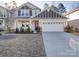 Charming two-story home featuring a pristine lawn, covered porch, and a two-car garage at 5028 Colline Ct, Charlotte, NC 28216