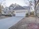 View of the front exterior showcasing the home's driveway, landscaping and charming architectural details at 5028 Colline Ct, Charlotte, NC 28216