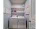 Bright laundry room featuring a washer and dryer, storage shelves and wallpaper at 5028 Colline Ct, Charlotte, NC 28216