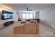 Spacious living room featuring plush seating, a modern ceiling fan, and abundant natural light at 5028 Colline Ct, Charlotte, NC 28216
