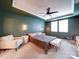 Bedroom features a ceiling fan, green walls, and an armchair, nightstands and windows at 5028 Colline Ct, Charlotte, NC 28216