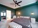 Bedroom features a ceiling fan, green walls, an armchair, and a view into the bathroom at 5028 Colline Ct, Charlotte, NC 28216