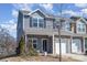 Two-story townhome with gray siding, stone accents, and an attached garage at 6503 Revolutionary Trl, Charlotte, NC 28217
