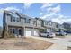 Street view of townhomes with attached garages and gray and brown exterior finishes at 6503 Revolutionary Trl, Charlotte, NC 28217
