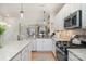 White kitchen showcasing stainless steel appliances, granite countertops, and an open layout connecting to other living areas at 6503 Revolutionary Trl, Charlotte, NC 28217