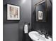Elegant powder room features charcoal gray walls, framed artwork, stylish fixtures and a white porcelain sink at 6509 Gopher Rd, Lancaster, SC 29720