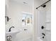 Bathroom featuring a pedestal sink, shower with black hardware, and a window providing natural light at 717 Perth Rd, Troutman, NC 28166