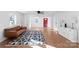 Bright living room featuring hardwood floors, a modern rug, and a red front door at 717 Perth Rd, Troutman, NC 28166