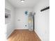 Bright utility room features wood-look flooring, shelving, and a modern water heater with wall-mounted fixtures at 717 Perth Rd, Troutman, NC 28166