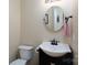 Half bath featuring pedestal sink, round mirror, and neutral decor at 7500 Grabill Dr, Charlotte, NC 28269