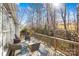 Inviting back porch features cozy seating, a wood railing, and a view of the serene, wooded surroundings at 8020 Harrington Woods Rd, Charlotte, NC 28269