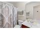 A cozy bathroom featuring a vanity with sink, toilet, and a shower/tub with a decorative patterned curtain at 8020 Harrington Woods Rd, Charlotte, NC 28269