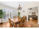 Bright dining room with hardwood floors, a wooden table with six chairs, and large windows with plantation shutters at 8020 Harrington Woods Rd, Charlotte, NC 28269