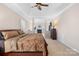 A large bedroom boasts tray ceilings, a ceiling fan, and a connected sitting area with a fireplace at 8020 Harrington Woods Rd, Charlotte, NC 28269