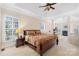 Serene main bedroom with a tray ceiling, neutral walls, plush carpet, and a view to the sitting area with fireplace at 8020 Harrington Woods Rd, Charlotte, NC 28269