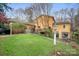Expansive backyard with a lush lawn, mature trees, and a charming deck for outdoor living at 8133 Strawberry Ln, Charlotte, NC 28277