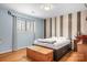 Inviting bedroom with hardwood floors, a storage trunk and wood accent wall at 8133 Strawberry Ln, Charlotte, NC 28277