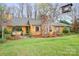 Charming single-Gathering home featuring a stone chimney, mature landscaping, and inviting front entrance at 8133 Strawberry Ln, Charlotte, NC 28277