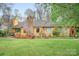 Inviting single Gathering home featuring a stone chimney, mature landscaping and a well-maintained lawn at 8133 Strawberry Ln, Charlotte, NC 28277