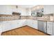Bright kitchen features white cabinets, tile backsplash, stainless steel appliances, and hardwood floors at 8133 Strawberry Ln, Charlotte, NC 28277