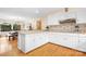 Well-lit kitchen featuring white cabinetry, granite counters, an eat-in bar, and hardwood flooring at 8133 Strawberry Ln, Charlotte, NC 28277