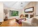 Bright living room with vaulted ceilings, large window views, and a charming brick fireplace at 8133 Strawberry Ln, Charlotte, NC 28277