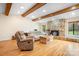 Inviting living room featuring a stone fireplace, wood beams, and gleaming hardwood floors at 8133 Strawberry Ln, Charlotte, NC 28277