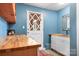 Functional mud room with wooden countertops, white cabinetry, and a convenient sink for everyday tasks at 8133 Strawberry Ln, Charlotte, NC 28277