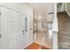 Inviting entryway with hardwood floors, staircase, and a view into the open-concept living area, showcasing natural light at 9705 Turning Wheel Dr, Charlotte, NC 28214